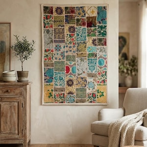 Puede incluir: Un tapiz rectangular con un diseño de patchwork compuesto por numerosos paneles de tela cuadrados pequeños. Cada panel muestra una combinación única de intrincados patrones florales, geométricos y de cachemira en colores vibrantes como rojo, azul, verde y oro.