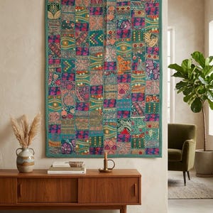 Può includere: Un arazzo rettangolare caratterizzato da un vivace design patchwork composto da numerosi piccoli quadrati di tessuto. Il tessuto mostra una varietà di intricati motivi floreali, paisley e geometrici nelle tonalità del verde acqua, rosa, oro e blu.
