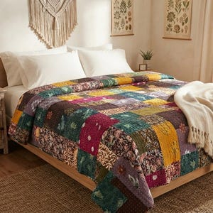 May include: A patchwork quilt featuring a variety of rectangular fabric blocks in shades of deep red, mustard yellow, forest green, and purple, adorned with intricate floral and geometric patterns, draped over a bed with a cream-colored throw blanket.
