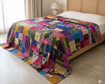 Puede incluir: Una colcha de retazos que presenta una variedad de cuadrados de tela coloridos en tonos azul, rosa, amarillo y verde con diversos patrones florales y geométricos. La colcha tiene costuras visibles y está colocada sobre una estructura de cama.