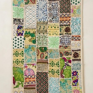 May include: A rectangular wall hanging featuring a patchwork design of various fabric squares. The textile displays a diverse array of colours including green, blue, yellow, pink, and brown, with intricate floral, geometric, and abstract patterns.