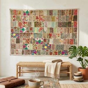 May include: A rectangular wall hanging featuring a patchwork design composed of numerous small fabric squares in various colors, including red, green, blue, and gold, with intricate floral and geometric patterns stitched together in a grid.