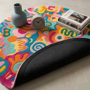Vibrant pink teal orange round doodle hand tufted wool rug on light wood floor in a maximalist bright living room.