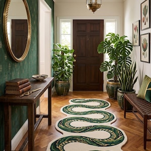Puede incluir: Una alfombra larga de color crema con forma de serpiente sinuosa con escamas verdes y verde azulado oscuro. La alfombra presenta una cabeza de serpiente detallada en un extremo y una cola afilada en el otro, colocada sobre un suelo de madera.