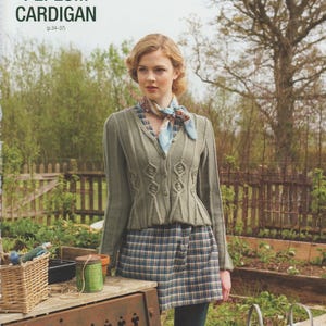 May include: A woman wearing a green peplum cardigan with a matching plaid skirt and a patterned scarf. The text "PEPLUM CARDIGAN" is at the top of the image. The background includes a garden setting with a wooden table and metal watering cans.
