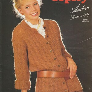 May include: A vintage magazine cover featuring a woman wearing a brown knit cardigan with a matching skirt and a brown leather belt. The text "Copley Andora Knits as 4ply" is displayed. The bust size is 32-40 inches.