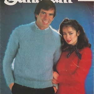 May include: A white ceramic mug with a black handle and the text "But First, Coffee" in a black, bold font. The mug is on a white surface. The mug is approximately 10 cm tall.