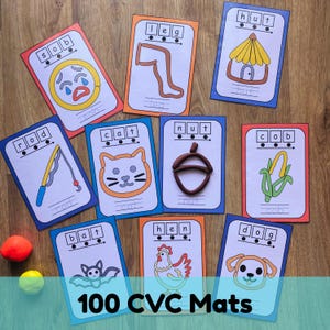 May include: A set of educational CVC word mats featuring illustrations of a sob, leg, hut, rod, cat, nut, cob, bat, hen, and dog. Each card includes boxes for spelling the word and a space for modeling clay shapes. Two small balls of clay are visible.