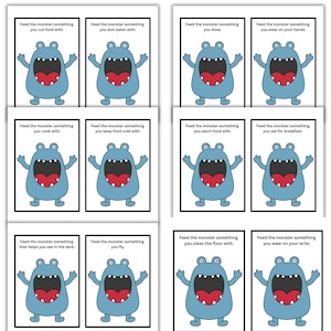 May include: A set of twelve cards featuring a cartoon blue monster with a large red mouth. Each card has a different prompt, such as "Feed the monster something you cut food with" or "Feed the monster something you wear on your wrist."