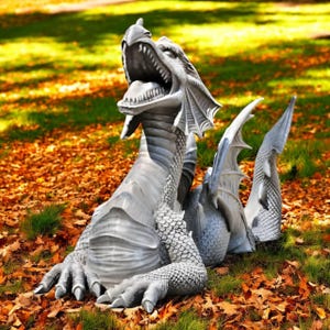 May include: A detailed, gray dragon statue with an open mouth, sharp teeth, and textured scales. The dragon is seated on a bed of fallen leaves and grass, with its wings and tail visible. A fantasy-themed garden ornament.