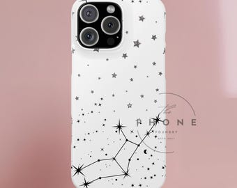 May include: White phone case with a constellation design. The case features a pattern of small stars and a constellation outline in black. The phone case has a camera cutout and a pink base.