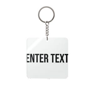 Puede incluir: Un llavero cuadrado blanco con el texto "ENTER TEXT" en negro. Cuenta con un anillo y una cadena plateados para sujetar a las llaves. Diseño sencillo y moderno, ideal para personalizar.