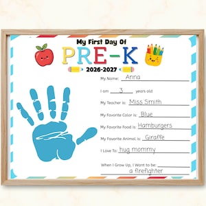 May include: A framed My First Day Of PRE-K 2026-2027 sign featuring a blue handprint, a red apple, and a yellow pencil cup graphic. The form includes handwritten lines for name, age, teacher, favourite colour, food, animal, hobbies, and future career.