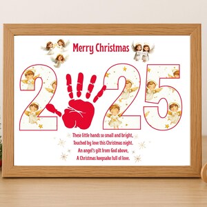 May include: A framed Christmas print featuring the numbers "225" with a red handprint. The words "Merry Christmas" are at the top, with angels and text at the bottom. The print is in a wooden frame.