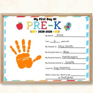 Puede incluir: Un letrero enmarcado de 'Mi primer día de Pre-K' con un diseño colorido. El letrero incluye el texto 'PRE-K 2025-2026', una huella de mano y secciones para completar con el nombre, la edad, el maestro, el color favorito, la comida, el animal y la futura carrera del niño.