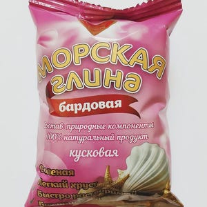 May include: A pink package with the words "МОРСКАЯ глина" in gold lettering. The package also features a seashell and starfish graphic. Text on the package includes "Состав: природные компоненты" and "100% натуральный продукт".