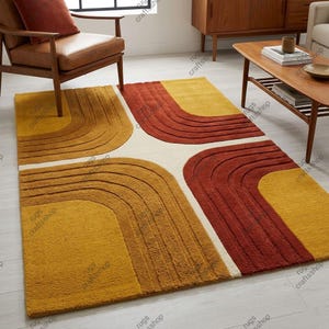 May include: A rectangular area rug featuring a geometric pattern of concentric arch shapes in shades of mustard yellow, burnt orange, and cream. The design consists of four corner sections with curved lines radiating towards the centre of the rug.