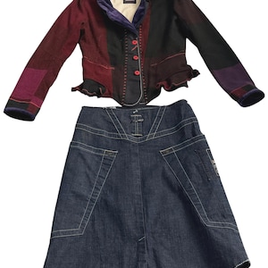 Puede incluir: Un conjunto de dos piezas con una chaqueta patchwork y una falda vaquera. La chaqueta tiene un esquema de color burdeos, negro y morado con costuras rojas y un cuello de terciopelo. La falda es de mezclilla oscura con detalles de bolsillos.