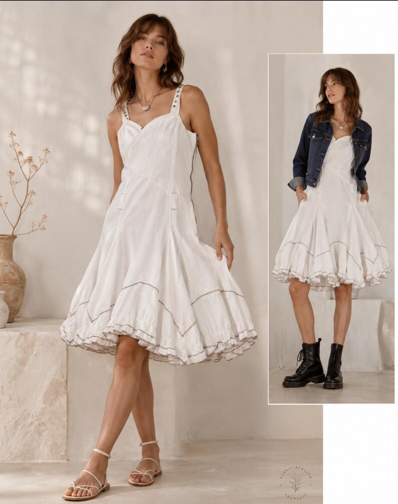 K&ouml;nnte beinhalten: Ein wei&szlig;es &auml;rmelloses knielanges Kleid mit eckigem Ausschnitt, breiten Tr&auml;gern und einem ausgestellten Rock mit ger&uuml;schtem Saum und dunklen Kontrastn&auml;hten. Das Kleid hat ein figurbetontes Oberteil und einen seitlichen Rei&szlig;verschluss.