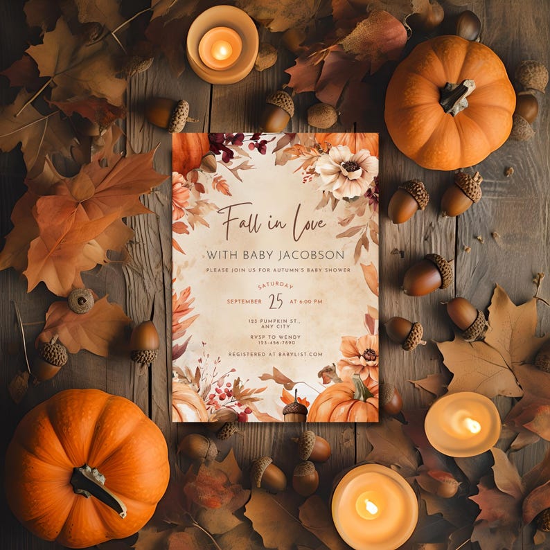 Puede incluir: Una invitaci&oacute;n a un baby shower con tem&aacute;tica oto&ntilde;al con el texto "Fall in Love with Baby Jacobson". La invitaci&oacute;n est&aacute; rodeada de calabazas, bellotas, hojas de oto&ntilde;o y velas encendidas.