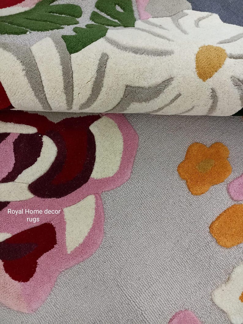 May include: Close-up of two floral rugs. The top rug features white, green, and gray floral designs. The bottom rug has pink, red, and orange floral patterns. The text "Royal Home decor rugs" is visible.