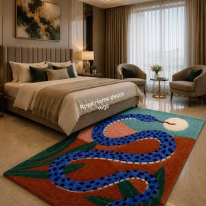 May include: A bedroom rug with a snake design. The rug features a blue snake with black spots on a background of red, teal, and green. The rug has the text "Royal Home decor rugs".