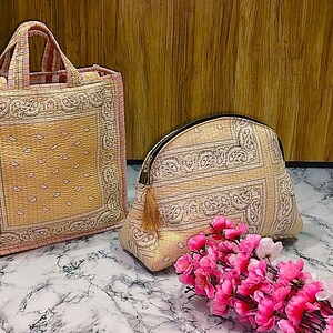 May include: A tote bag and a cosmetic bag with a matching paisley pattern in beige and pink. The tote bag has two handles and the cosmetic bag has a zipper closure. A bouquet of pink flowers is in the foreground.