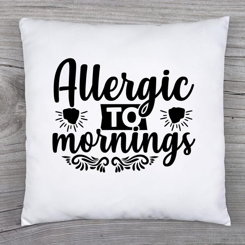 May include: White square pillow with the text "Allergic to mornings" in black script. The design includes stylized sunbursts and decorative flourishes, creating a playful and relatable statement for home decor.