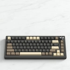 May include: A dark gray mechanical keyboard with a variety of keycap colors, including beige, brown, and gray. The keyboard has a silver knob and a compact layout, ideal for computer enthusiasts.