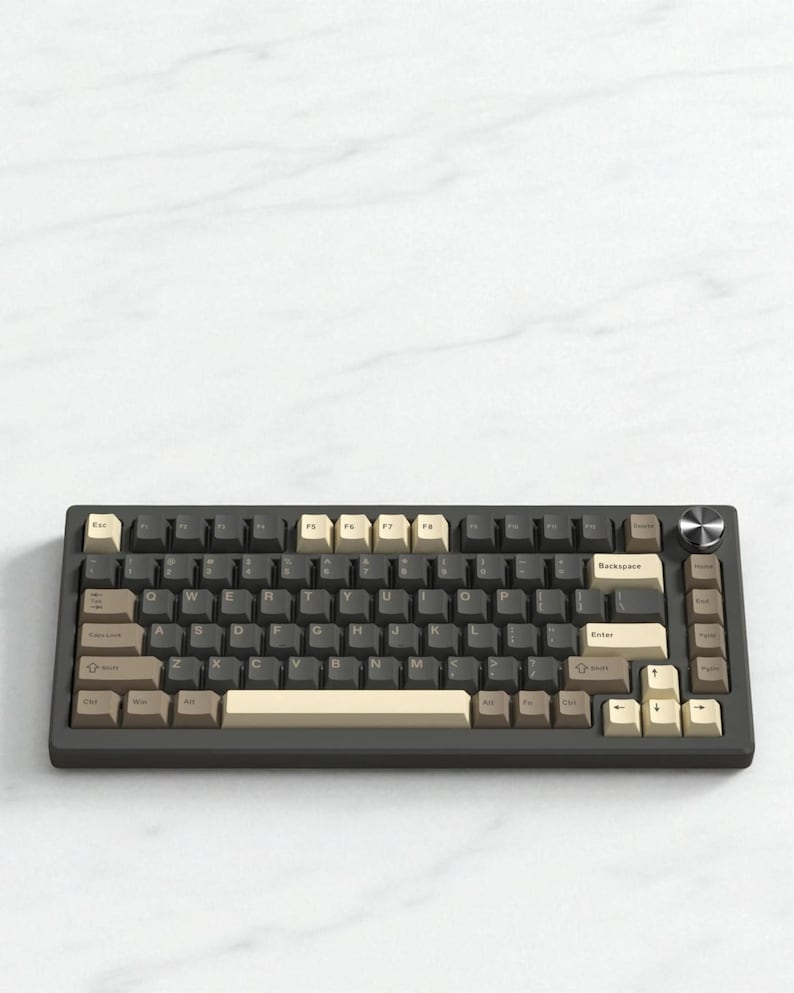 May include: A dark gray mechanical keyboard with a variety of keycap colors, including beige, brown, and gray. The keyboard has a silver knob and a compact layout, ideal for computer enthusiasts.