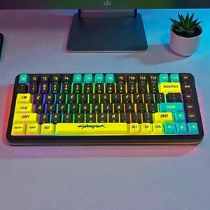 Pode incluir: Um teclado mecânico preto e amarelo com teclas multicoloridas. O teclado apresenta a palavra "Cyberpunk" na barra de espaço e possui uma variedade de teclas de função. As teclas são retroiluminadas com um efeito arco-íris.