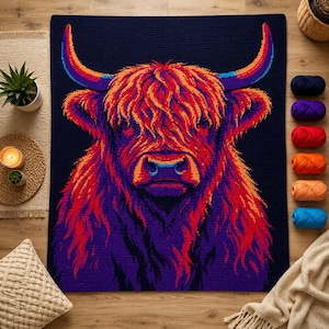 May include: A rectangular crochet blanket featuring a vibrant, multi-colored portrait of a Highland cow against a dark navy background. The cow is rendered in shades of bright red, orange, and purple, with long, shaggy fur and prominent curved horns.