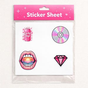 Puede incluir: Una hoja de pegatinas con cuatro diseños coloridos: una lata rosa de "Girly Pop", un CD holográfico, labios abiertos con un atardecer y un diamante rosa. El embalaje es rosa y tiene el texto "Sticker Sheet".