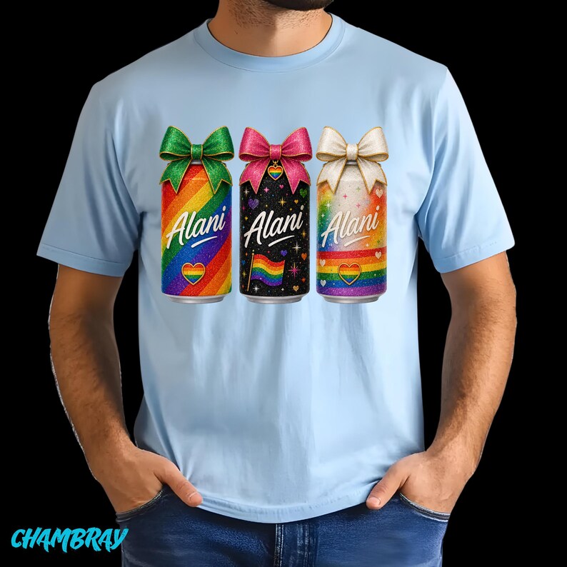 Pu&ograve; includere: T-shirt azzurra con tre lattine colorate con fiocchi. Ogni lattina ha la scritta "Alani" e un cuore arcobaleno. Le lattine hanno sfondi arcobaleno, neri e bianchi.