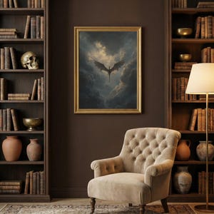 May include: A framed picture shows a dragon flying in a cloudy sky. The dragon is dark with spread wings. The artwork is in a gold frame, hung on a brown wall. A beige armchair is below the artwork, with bookshelves on either side.