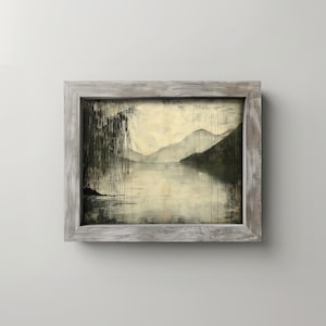 May include: A framed landscape painting depicting a tranquil lake scene with mountains in the distance. The artwork uses a palette of grey and beige, with a weeping willow on the left. The frame is made of weathered wood.