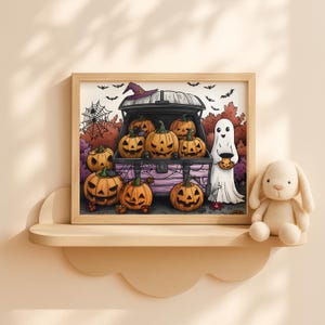 Op de afbeelding: Een ingelijste Halloween-illustratie met uitgesneden pompoenen, een heksenhoed en een spook met een pompoenemmer. Het kunstwerk is geplaatst tegen een achtergrond van herfstbladeren en vleermuizen, met een decoratief plankje en een knuffelkonijn.
