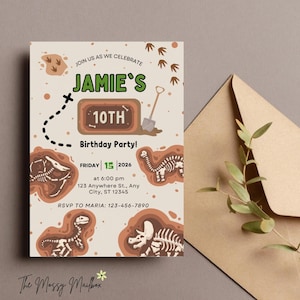Peut inclure: Une invitation d'anniversaire beige avec des fossiles de dinosaures et le texte "Jamie's 10th Birthday Party!". L'invitation comprend la date, l'heure et le lieu. Une enveloppe marron et de la verdure sont en arrière-plan.