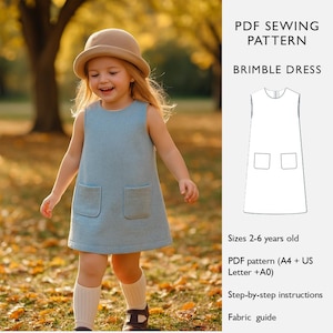 Może przedstawiać: Małe dziecko w jasnoniebieskiej sukience bez rękawów z dwiema przednimi kieszeniami i pasującym kapeluszem. Obraz reklamuje wzór szycia PDF o nazwie "Brimble Dress", z rozmiarami dla dzieci w wieku 2-6 lat. Obraz zawiera również instrukcje krok po kroku.