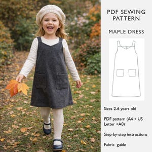 May include: A young child wearing a gray Maple dress with two front pockets, a white long-sleeved shirt, and a cream-colored beret. The child is holding fall leaves. The image also includes a PDF sewing pattern for the dress, with sizes for children aged 2-6 years old.