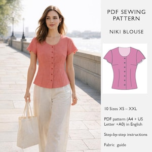 May include: A woman wearing a coral-colored short-sleeved blouse with a button-up front and cream-colored pants. The image includes a diagram of the blouse and text that reads "PDF SEWING PATTERN NIKI BLOUSE".