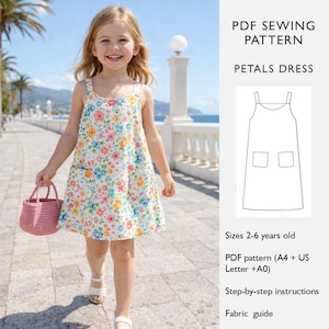 以下が含まれることがあります： 花柄のドレスを着た女の子。ドレスは白地にカラフルな花柄で、前に2つのポケットと細いストラップが付いています。彼女はピンクの織りバスケットを持っています。画像には「Petals Dress」のPDF縫製パターンも含まれています。