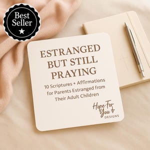Pode incluir: Um cartão quadrado com o texto "ESTRANGED BUT STILL PRAYING" e as palavras "10 Scriptures + Affirmations for Parents Estranged from Their Adult Children." Um distintivo "Best Seller" está no canto superior esquerdo. Um caderno e uma caneta estão no fundo.