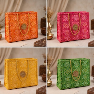 May include: Four colorful tote bags with intricate floral patterns. The bags are in orange, pink, yellow, and green, each with a matching handle and a decorative circular embellishment. The bags are displayed on a neutral surface.
