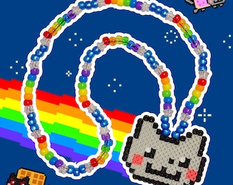May include: A necklace featuring a repeating pattern of rainbow-colored plastic beads separated by small, clear, star-shaped spacers. The necklace includes a large, flat, pixelated cat pendant made of small square beads in gray, black, and pink.