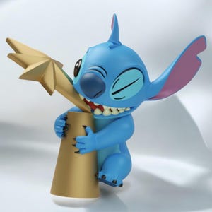 Peut inclure: Figurine bleue de Stitch tenant un trophée doré. La figurine sourit et serre le trophée. Le trophée est surmonté d'une étoile. La figurine a de grandes oreilles avec l'intérieur rose.
