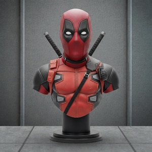 Può includere: Un busto di Deadpool rosso e nero con due katane sul retro. Il busto presenta un design dettagliato della maschera e del costume del personaggio, con un cinturino nero e una granata. La statua è montata su una base nera.