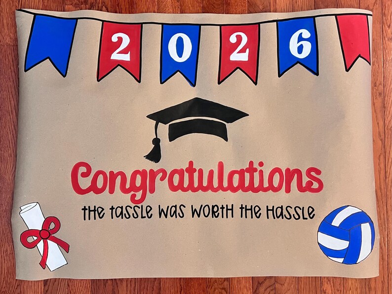 The image is a graduation-themed banner with the year "2026" displayed, a graduation cap, and a volleyball. The text "Congratulations the tassel was worth the Hassle" is written below the graduation cap.