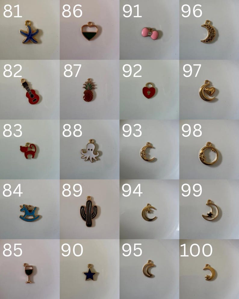 K&ouml;nnte beinhalten: Eine Sammlung von zwanzig kleinen Metallanh&auml;ngern, die in einem Raster angeordnet und von 81 bis 100 nummeriert sind. Die Anh&auml;nger haben verschiedene Formen, darunter ein blauer Seestern, eine rote Gitarre, eine Katze, ein Schaukelpferd, ein Weinglas, ein Herz, eine Ananas, ein Oktopus, ein Kaktus, ein Stern und Monde.