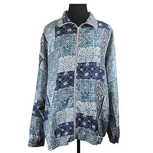May include: A blue and white patterned zip-up jacket. The jacket has a collared neckline, long sleeves, and a ribbed hem. The design is a patchwork of floral and geometric patterns in various shades of blue.